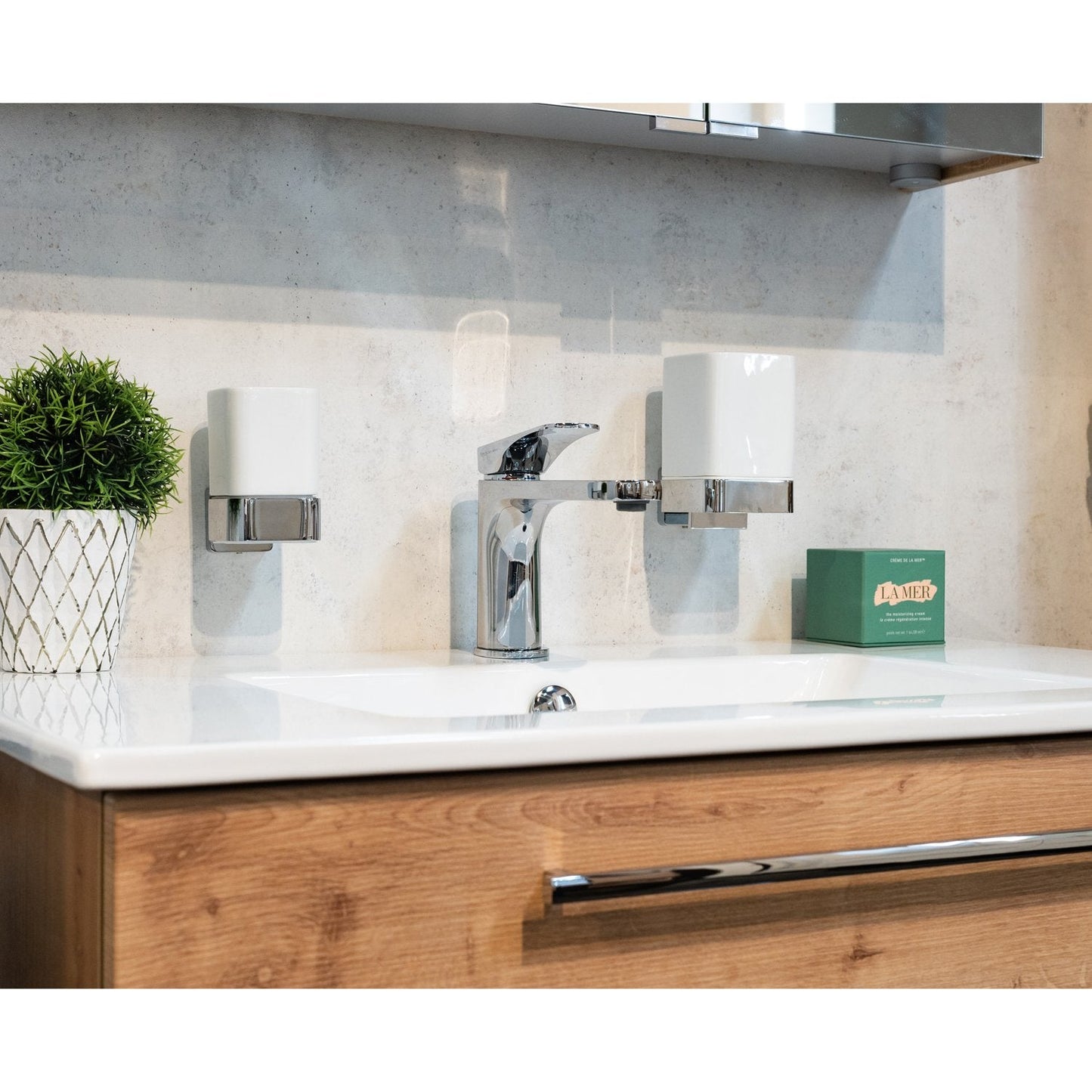 Modern bathroom sink with wooden cabinets and wall mounted bathroom accessories