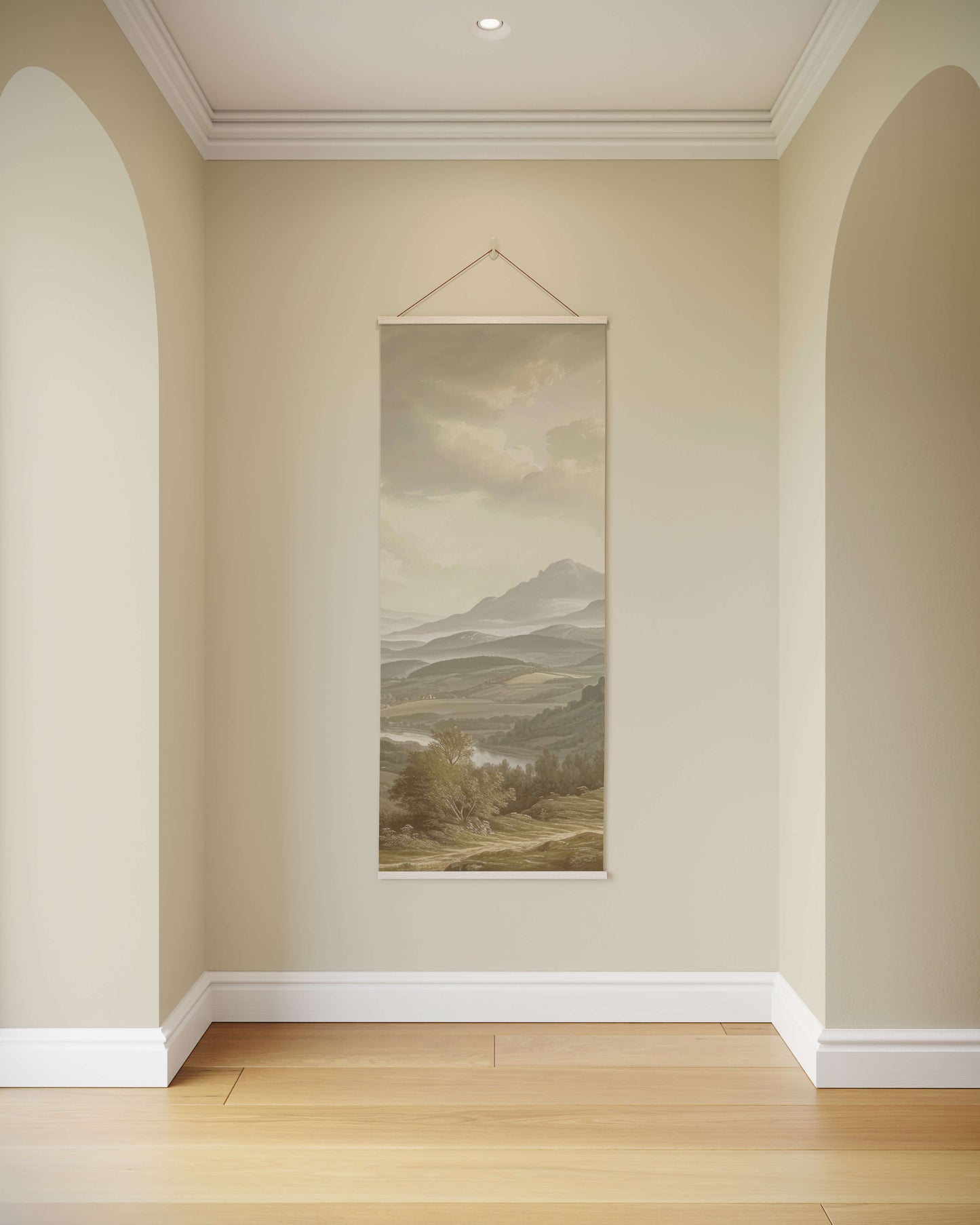 Wall art of a mountain landscape hanging on a beige wall.