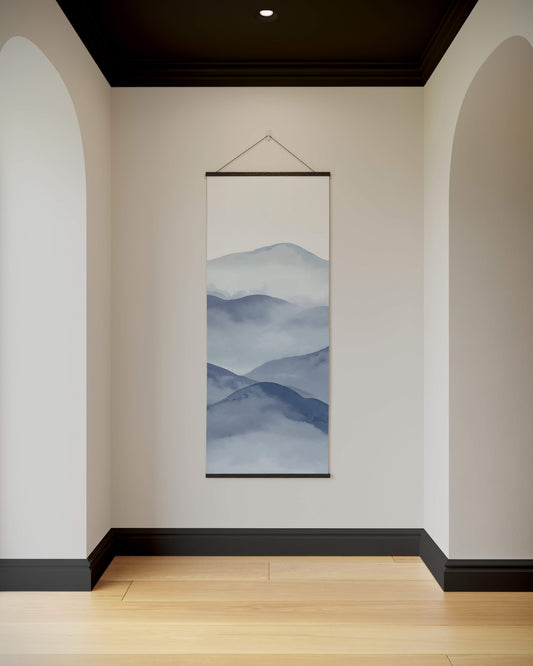 Wall art of mountain landscape hanging in a room with white walls and wooden floor.