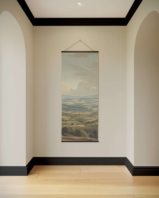 Wall art of a landscape hanging in a room with arched doorways and a wooden floor.