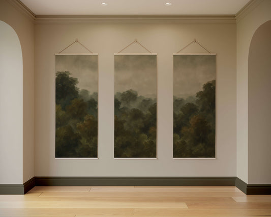 Three landscape paintings hanging on a wall in a room with wooden flooring.