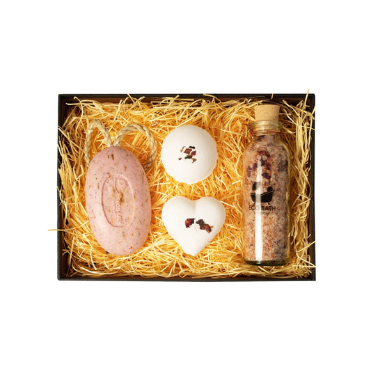 Bath product set with a bottle, soap, and bath bombs on straw in a box.