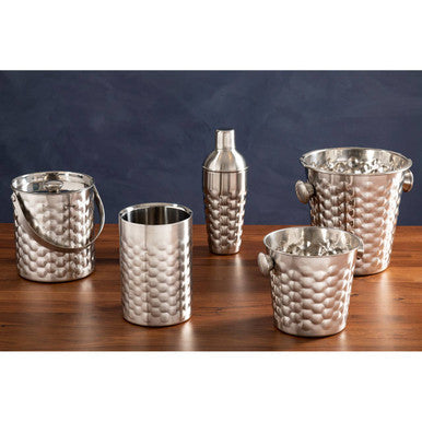 Set of silver cocktail shakers and ice buckets on a wooden surface with a dark background
