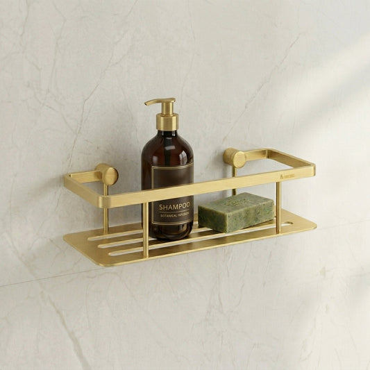 Smedbo Sideline DV3001S Brushed Brass Shower Basket on White Marble Wall — Styled with Amber Botanical Shampoo Pump Bottle and Green Natural Soap Bar