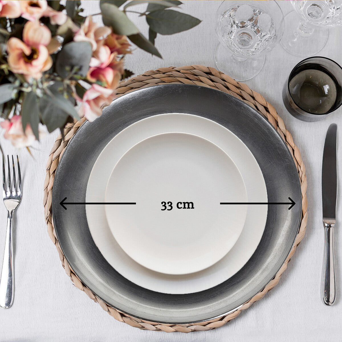 Silver coupe charger plate styled with tableware for a formal dinner