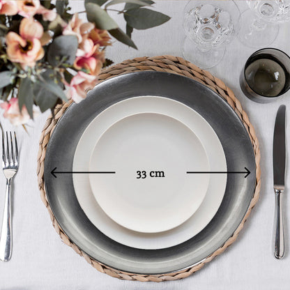 Silver coupe charger plate styled with tableware for a formal dinner