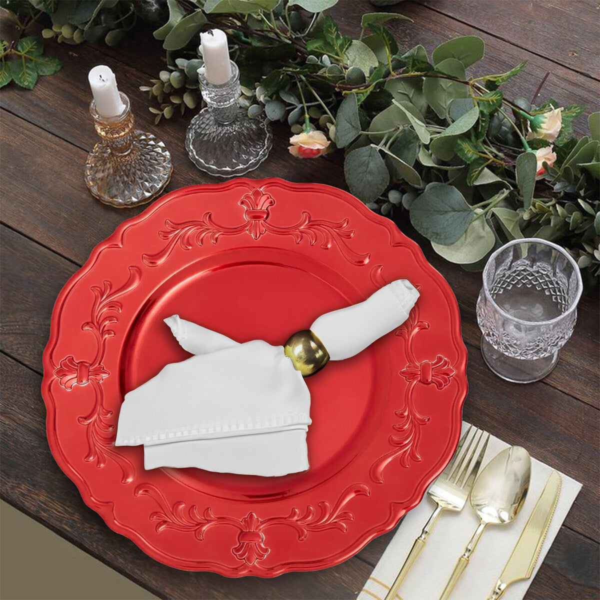 Red baroque charger plate laid beneath a dinner plate in a place setting