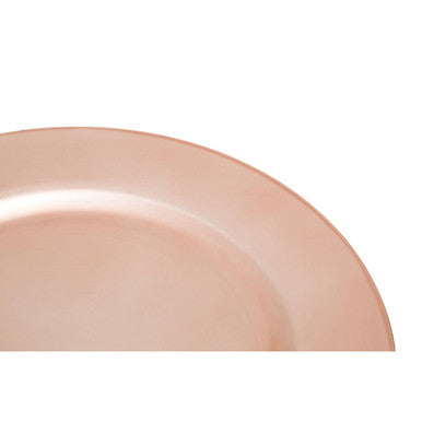 Rose gold charger plate laid beneath a dinner plate in a table setting