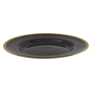 Black glass charger plate styled on a dining table as part of a place setting