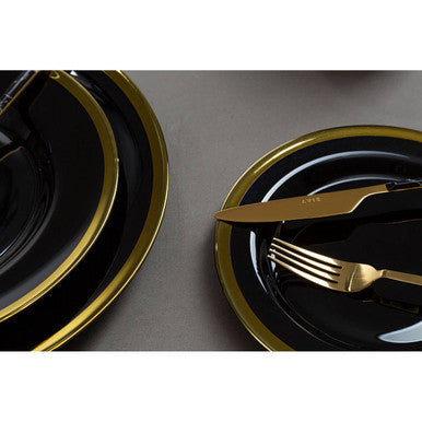 Black glass charger plate styled with tableware for a formal dinner setting