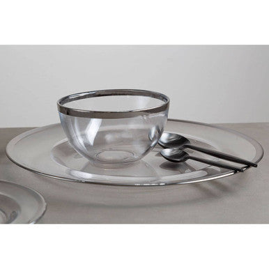 Glass charger plate styled with glassware and cutlery on a dining table