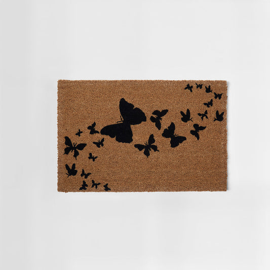 Doormat with black butterfly design on a beige background