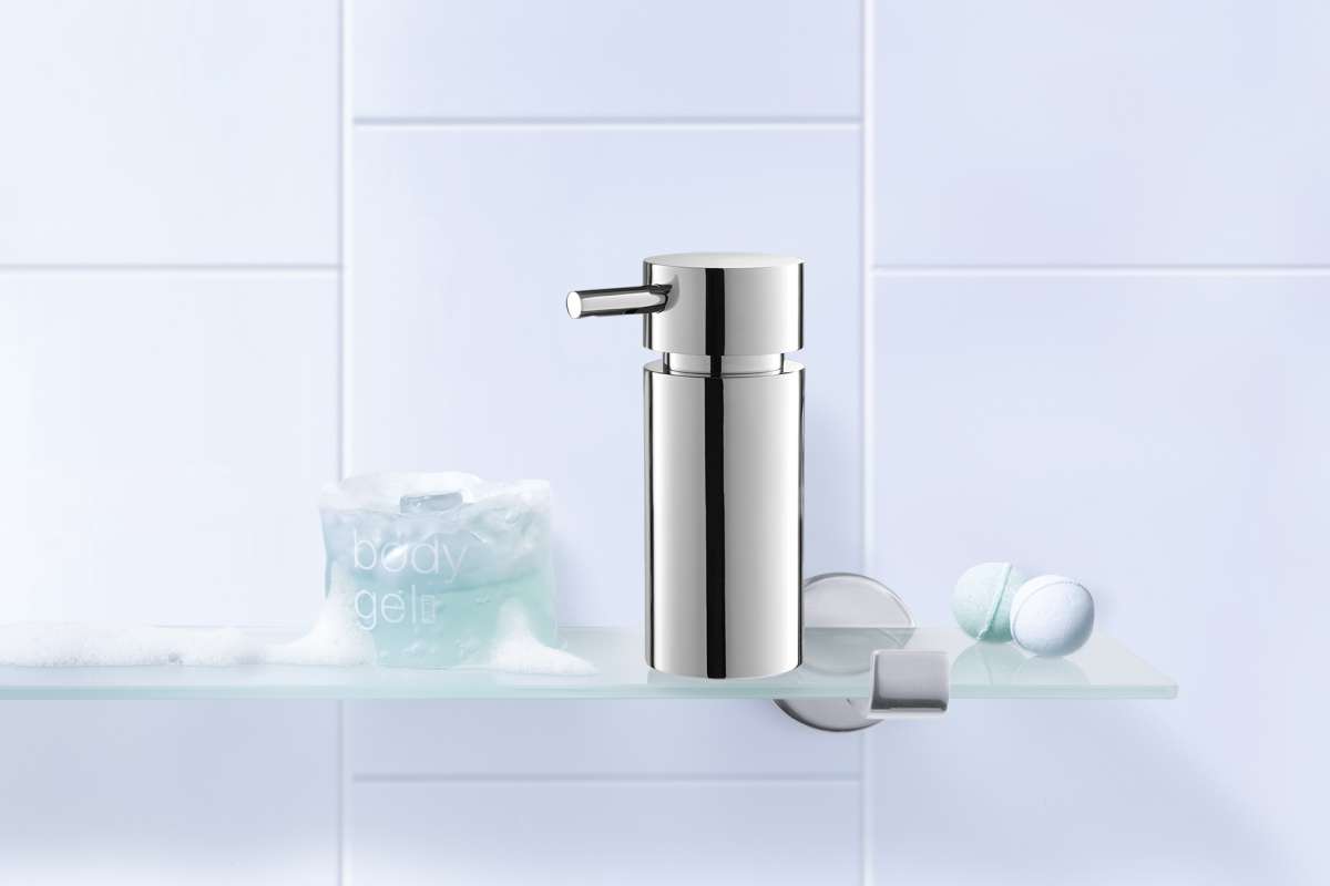 Chrome soap dispenser on a white tiled wall