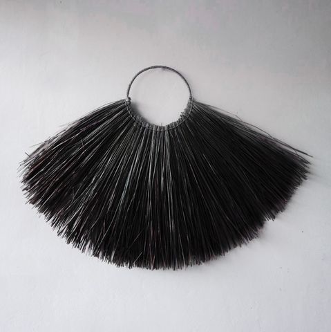 Black fringe hoop fan on a light gray background