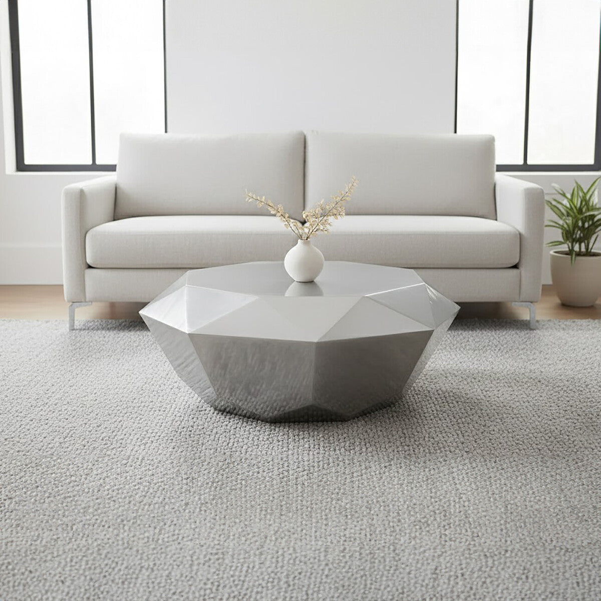 Modern living room with a geometric coffee table and white sofa.