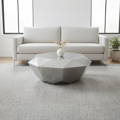 Modern living room with a geometric coffee table and white sofa.