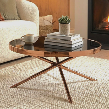 Bronze coffee table with books and a cup in a living room setting