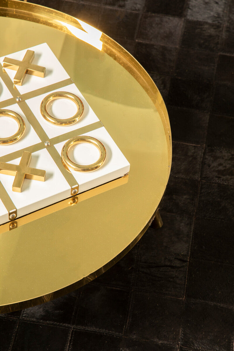 Gold and white game board with cross and circle design on a round gold table.