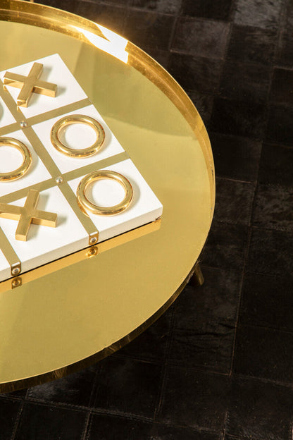 Gold and white game board with cross and circle design on a round gold table.