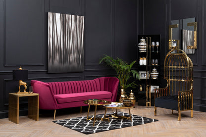Modern living room with a pink sofa, gold chair, and decorative elements.