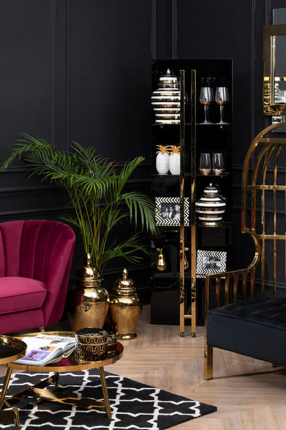 Modern interior with a pink sofa, gold accents, and decorative items.