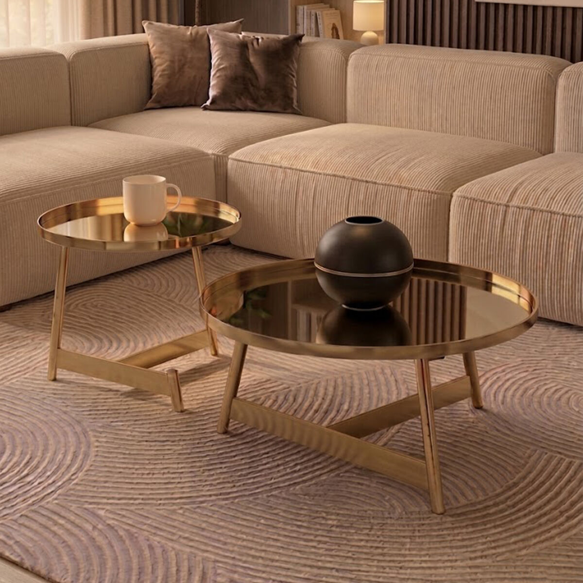 Beige sectional sofa with round gold coffee table and decorative items in a living room setting.