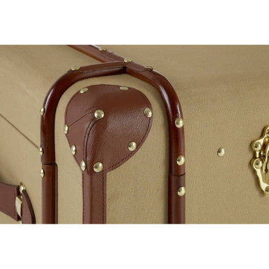 Close-up of a beige suitcase with brown handle and gold studs