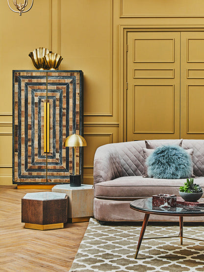 Modern living room with a stylish sofa, sideboard, and decor items against a mustard yellow wall.