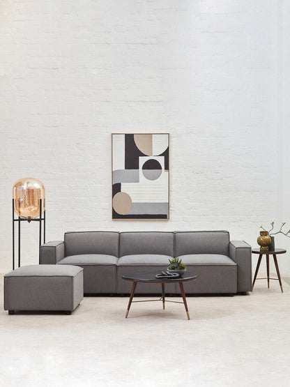 Modern living room with a gray sectional sofa, coffee table, and abstract art on the wall.