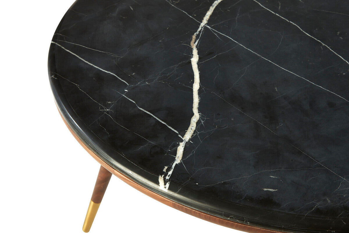Round black marble table with gold legs on a white background