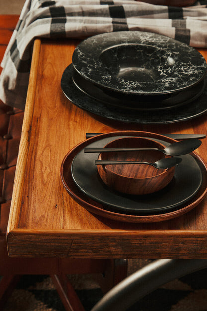 Round acacia plate shown as part of a table setting
