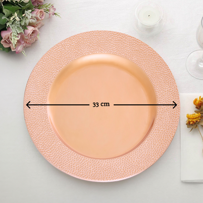 Rose gold charger plate laid beneath a dinner plate in a place setting
