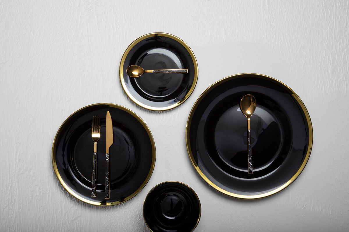 Four black glass charger plates styled across a dining table