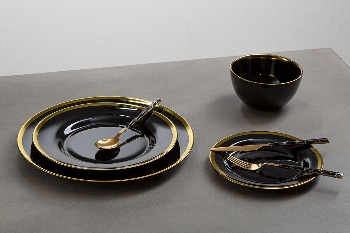 Black glass charger plates styled with tableware for a formal dinner