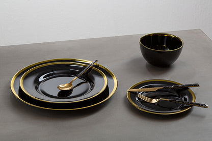 Black glass charger plates styled with tableware for a formal dinner