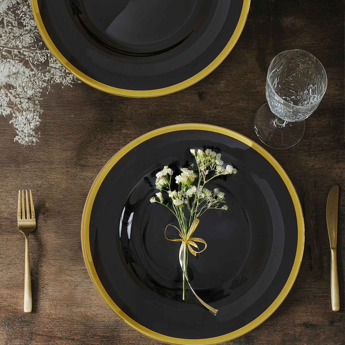 Black glass charger plate shown from above with gold rim visible