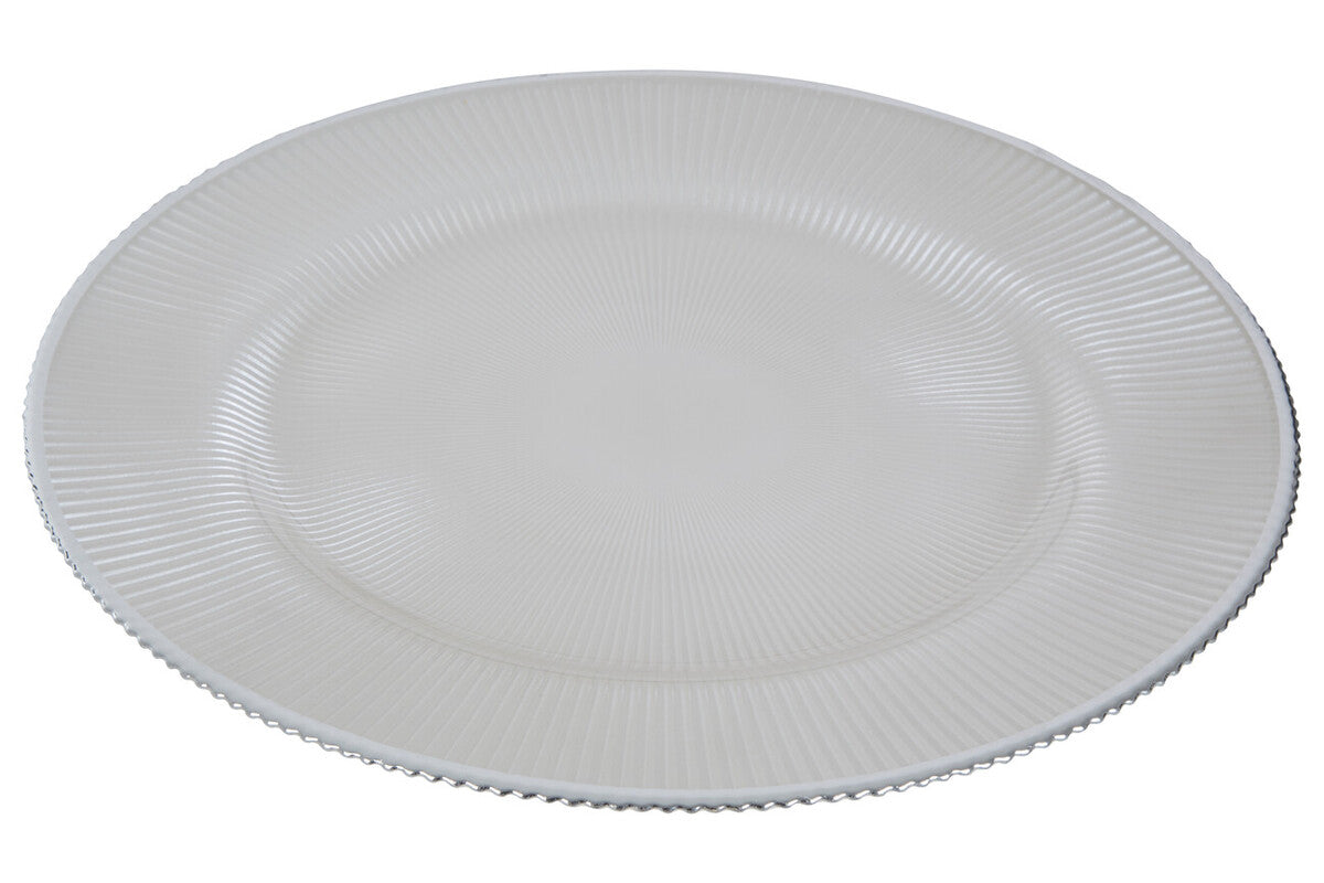 Four white glass charger plates styled across a dining table setting