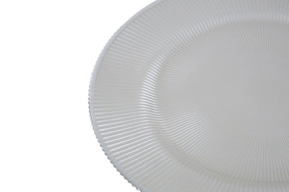 White glass charger plates styled with tableware for a formal dinner