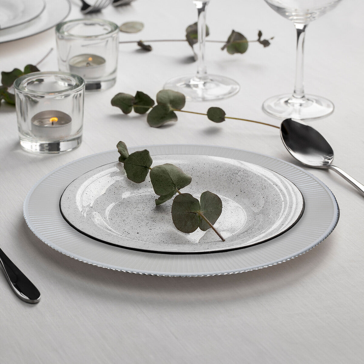 Set of four white embossed glass charger plates with silver rim, 33cm