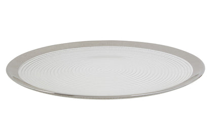 Glass coupe charger plate laid beneath a dinner plate in a place setting