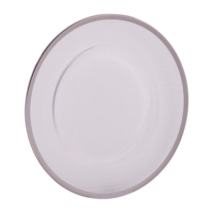 Four glass charger plates styled across a dining table setting