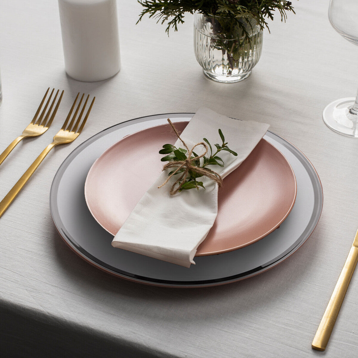 Glass charger plate laid beneath a dinner plate in a place setting