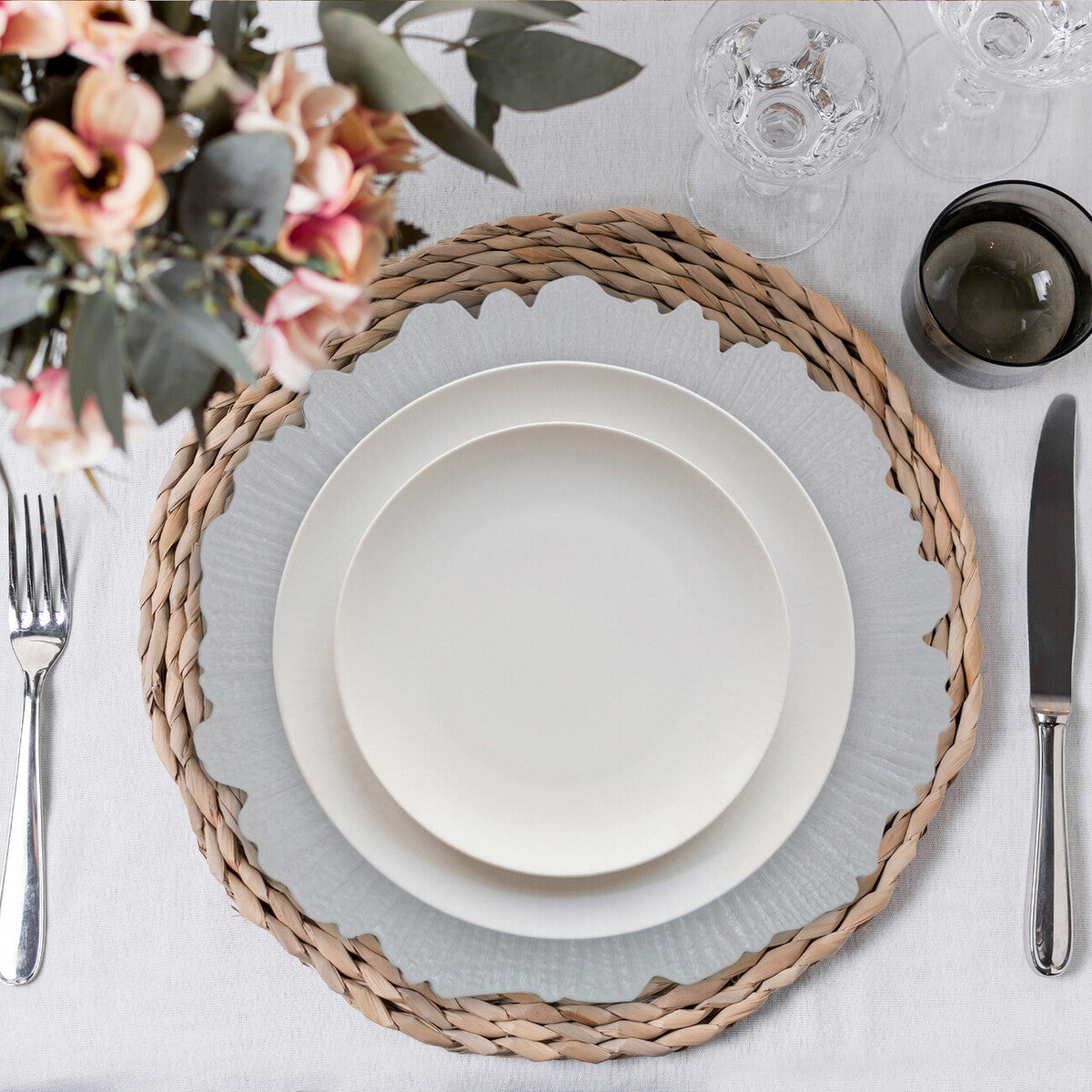 White reef charger plate styled with tableware for a formal dinner