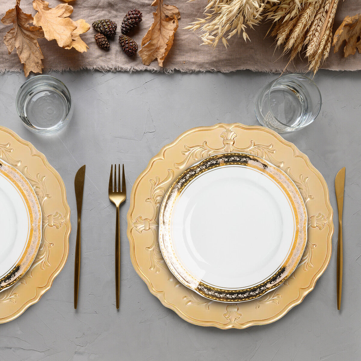 Gold baroque charger plate styled with tableware for a formal dinner
