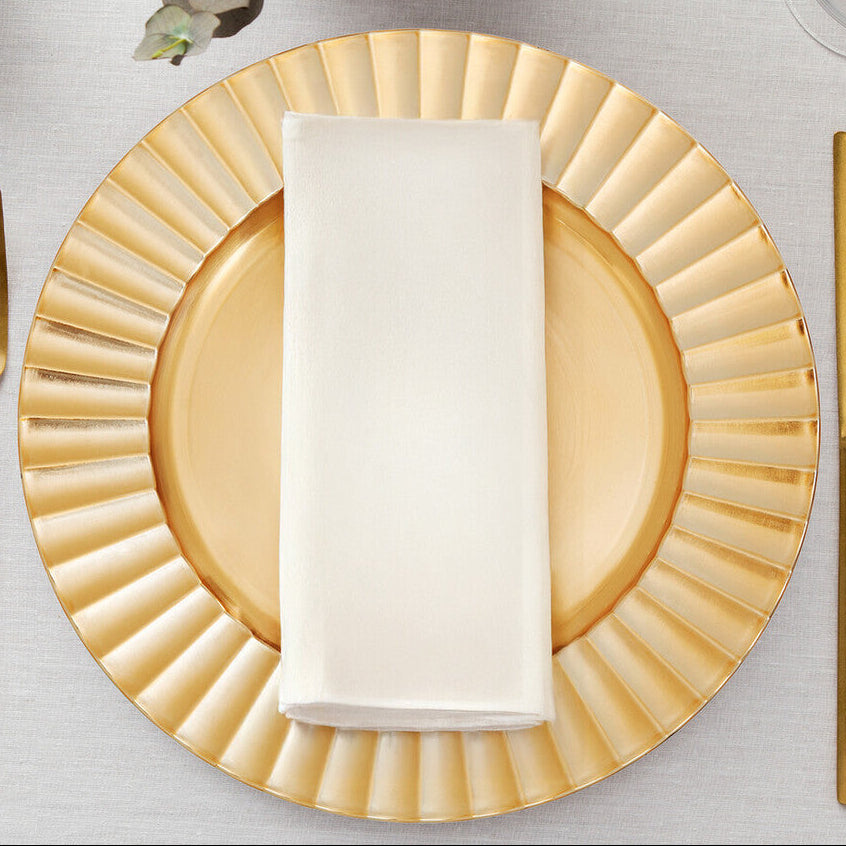 Gold wave charger plate styled on a dining table as part of a place setting