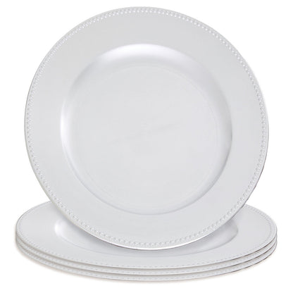 Silver charger plate laid beneath a dinner plate in a table setting