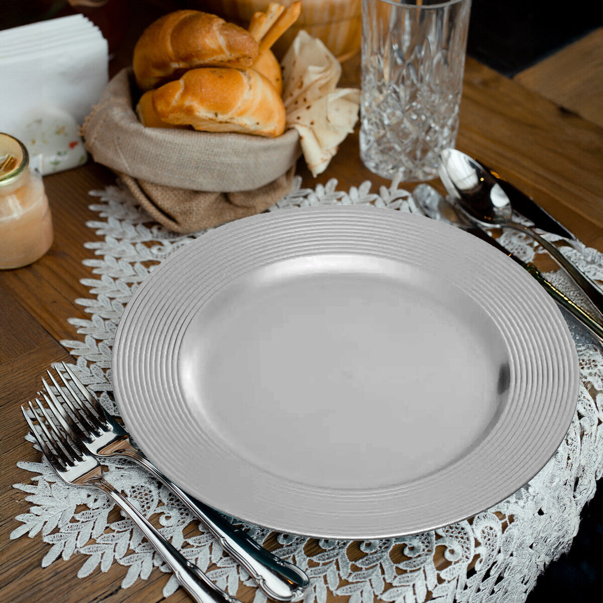 Silver charger plates stacked showing the ribbed rim texture