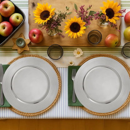 Four silver charger plates styled across a dining table
