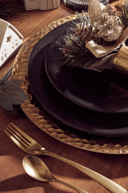 Close-up detail of the hammered rim on the gold charger plate