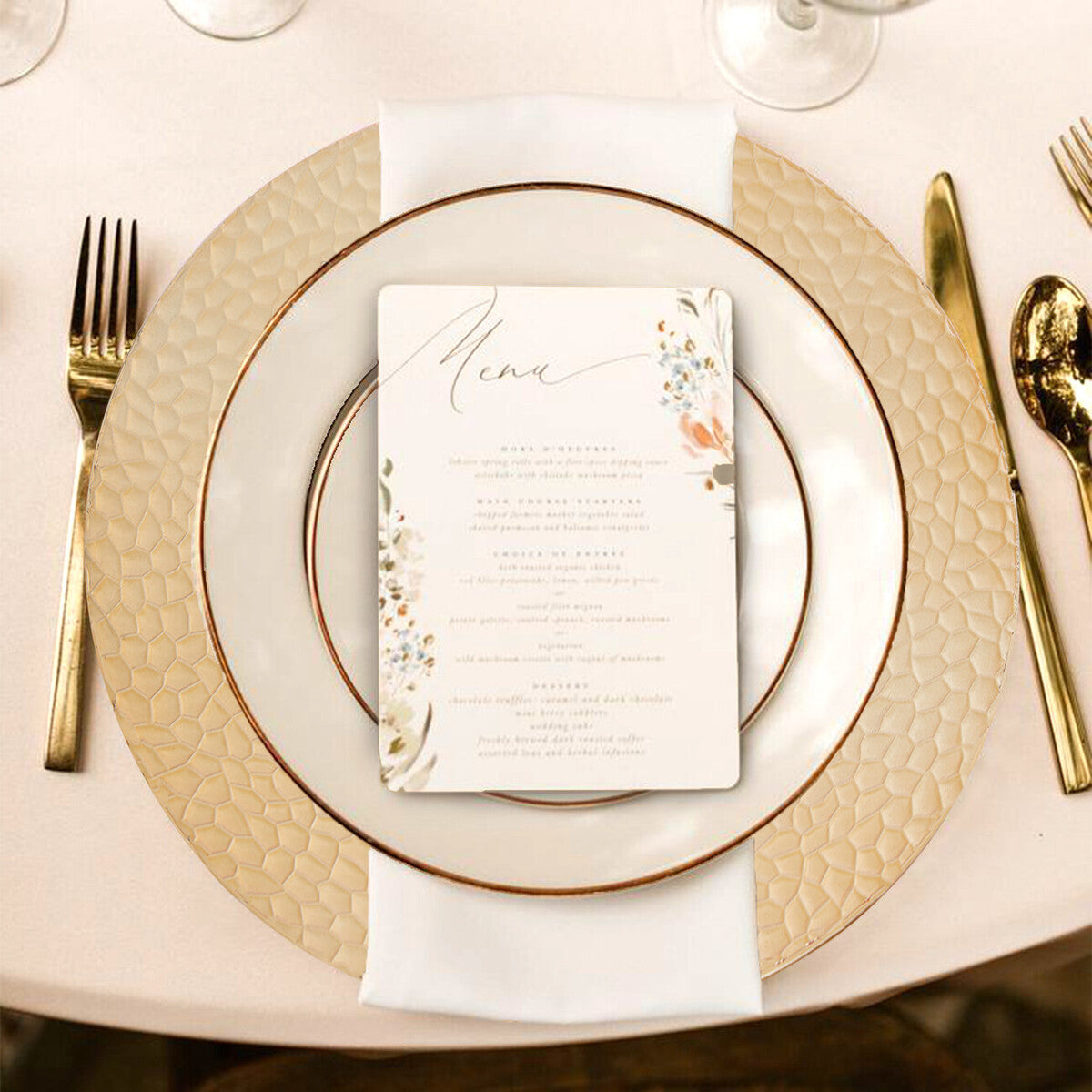 Gold charger plate laid beneath a dinner plate in a place setting
